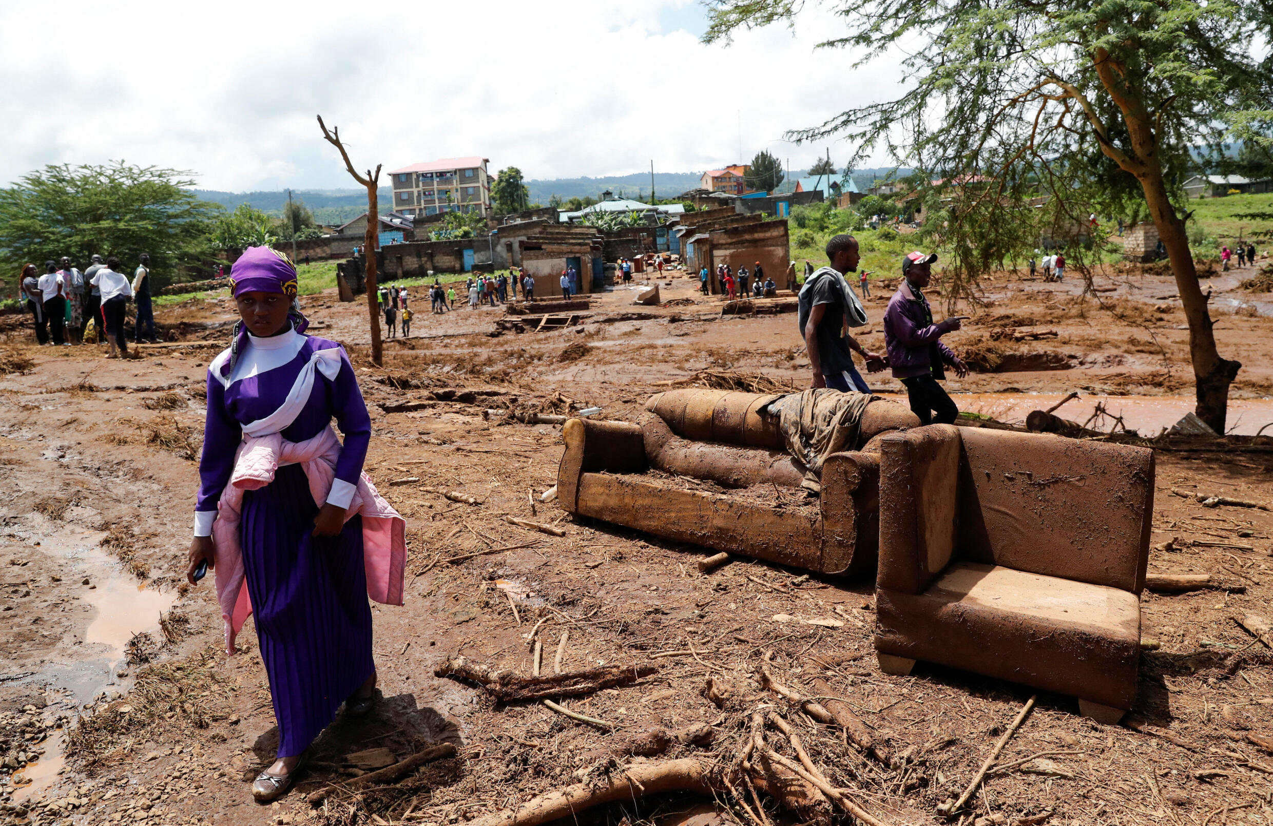 Eine Frau geht an Sofas vorbei, die weggespült wurden, nachdem schwere Sturzfluten am 29. April 2024 mehrere Häuser zerstört hatten, als ein Damm im Kamuchiri-Dorf Mai Mahiu, Nakuru County, Kenia, brach.