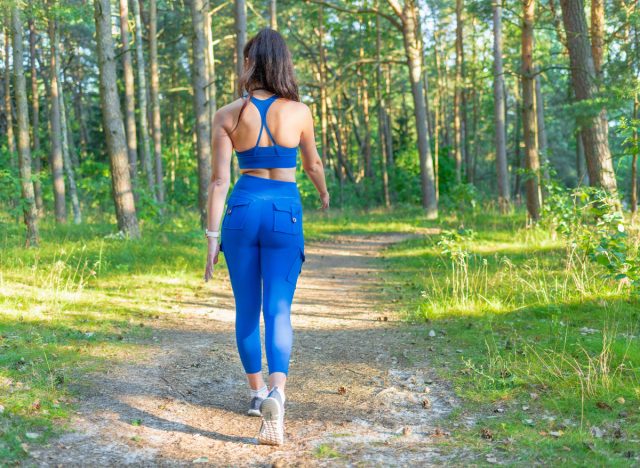 Frau geht auf Wegen, Konzept des täglichen Gehtrainings für Frauen, um fit zu werden